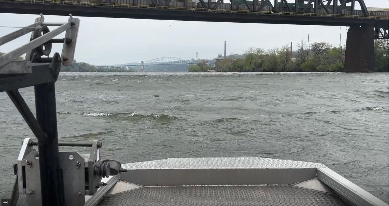 Ohio River during high flow near a bridge with Pittsburgh PA in background