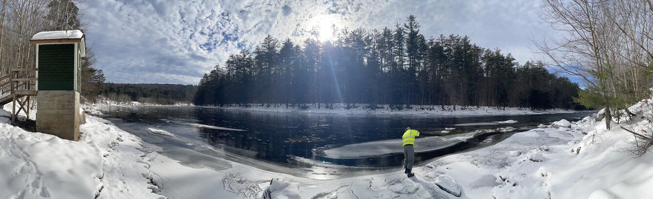 Lisle standing on edge of river conducting inspection