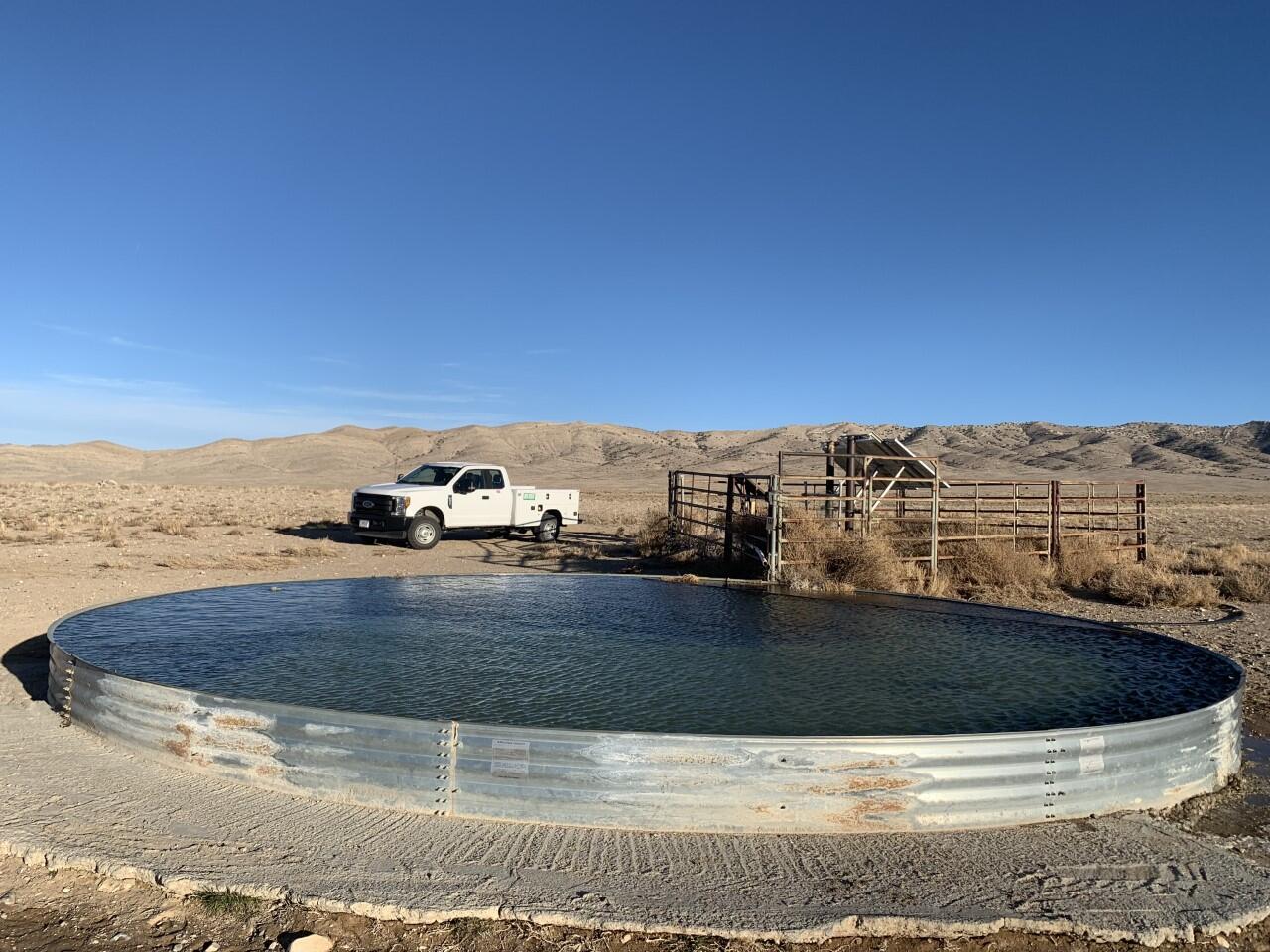 BLM stock tank is filled to the brim with water. 