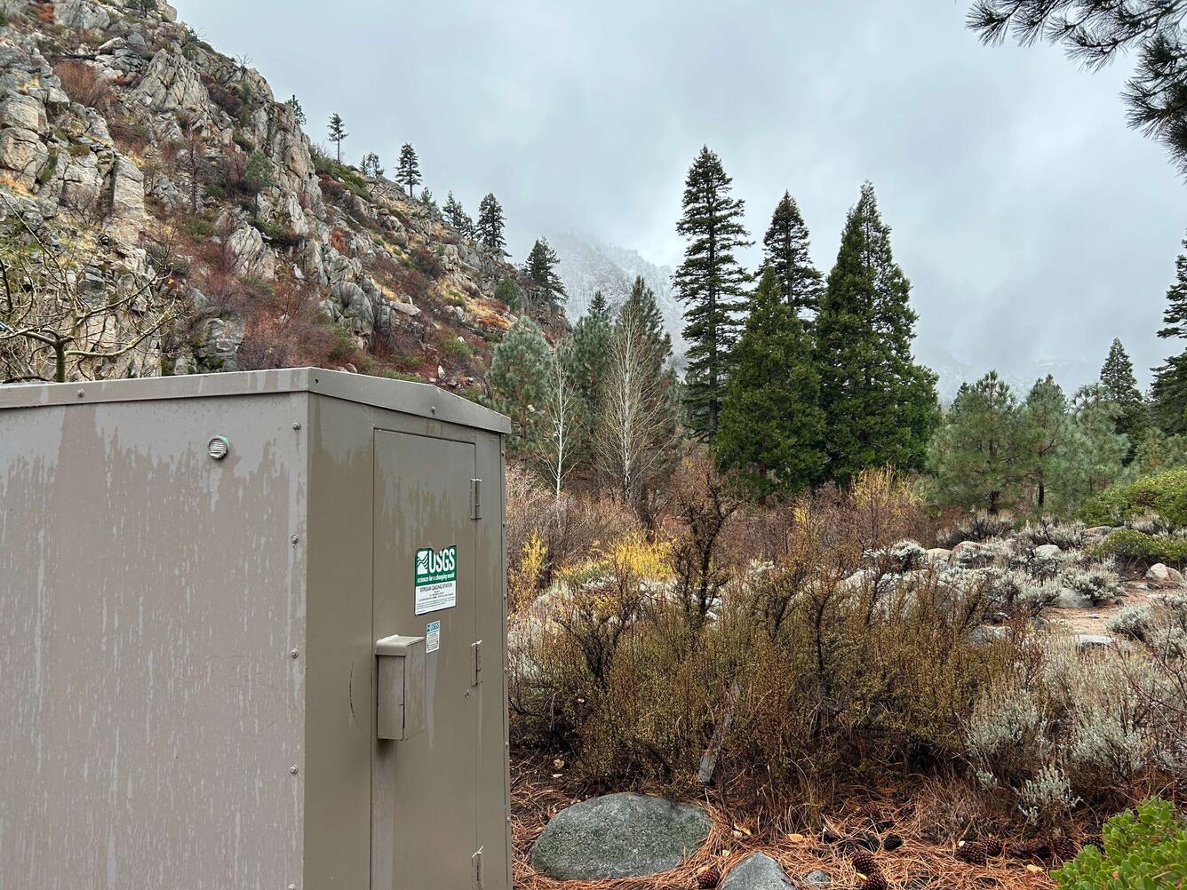 Cloudy sky over West Fork Carson River with rock outcrops, sagebrush, and pine trees.