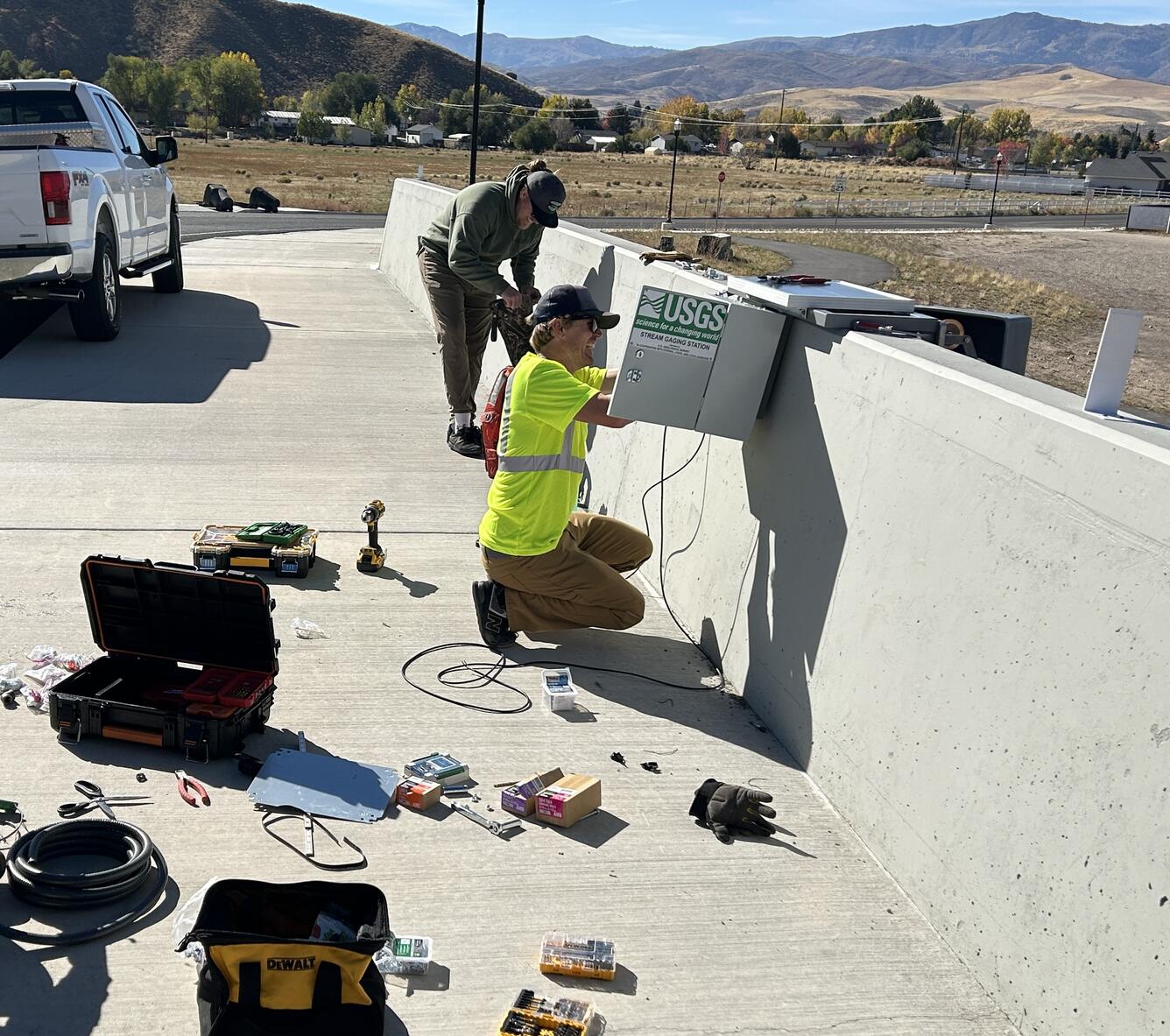 Employees on bridge with tools strung all over.