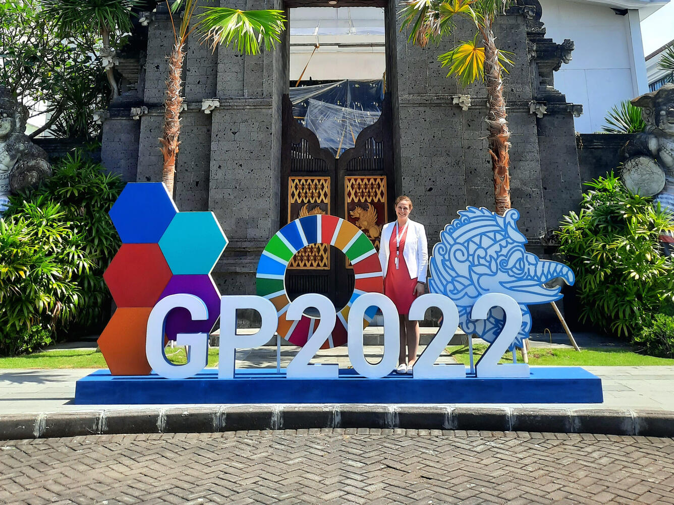 person standing next to sign that says GP2022 in bright colors