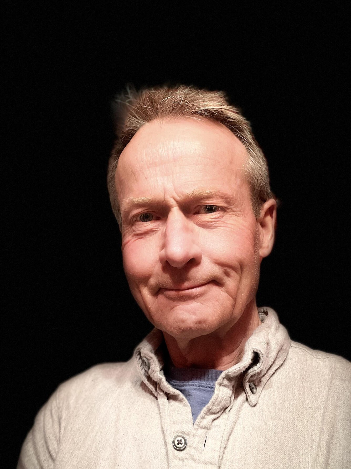 male scientist, smiling, wearing a tan shirt
