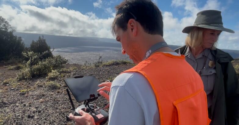 Color photo of USGS scientist and National Parks Service staff looking at the UAS operation screen. 