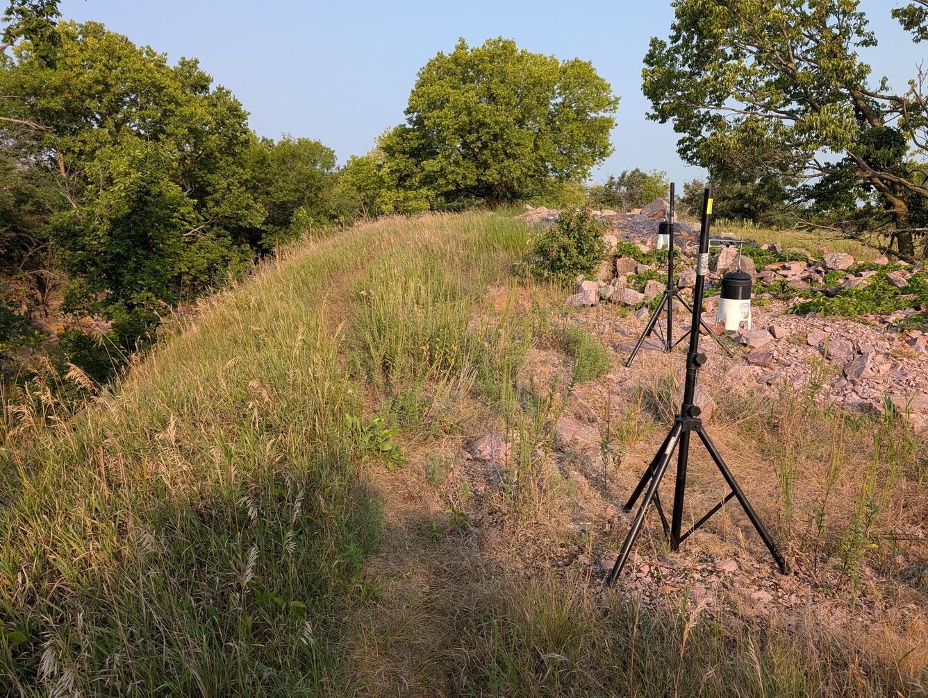 Air sampling units rest on top of a grassy and rocky hill