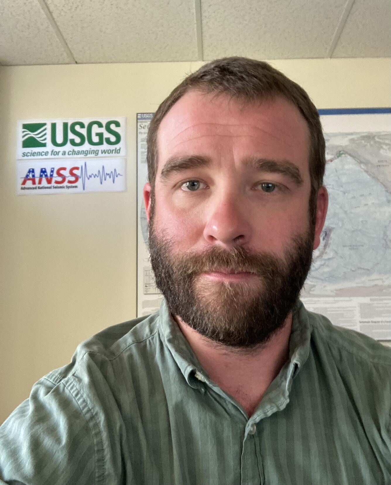 headshot of person with USGS logo in the background
