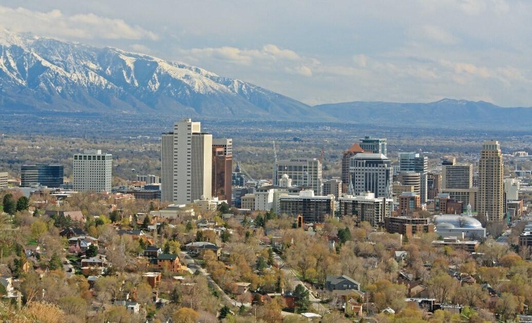 Photograph of a cityscape with mountains in the background.