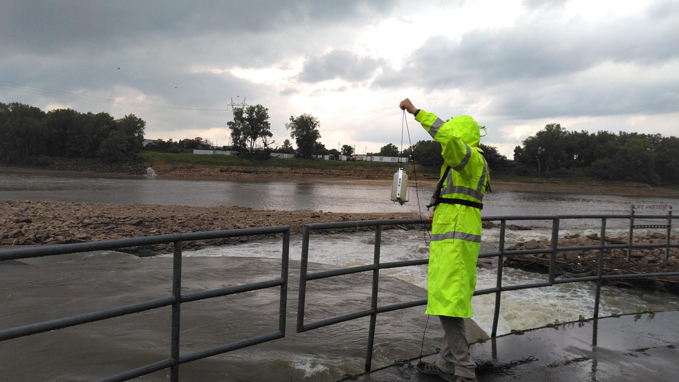USGS in Hi-Vis gear collecting sample at WaterOne.