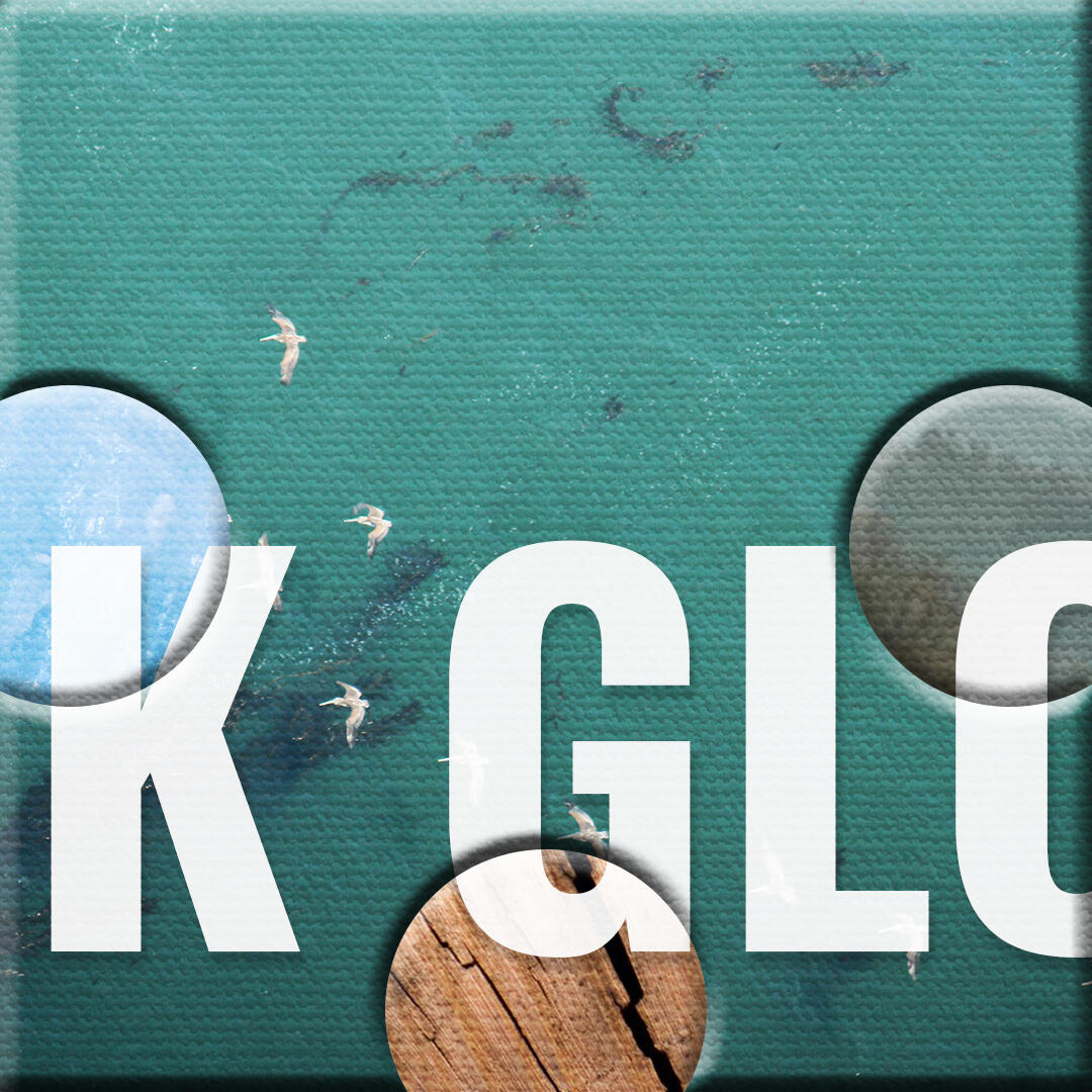 An image of a puzzle piece with a blue-green ocean on it. The piece has part of a word, but only the letters "K GLO" are visible.