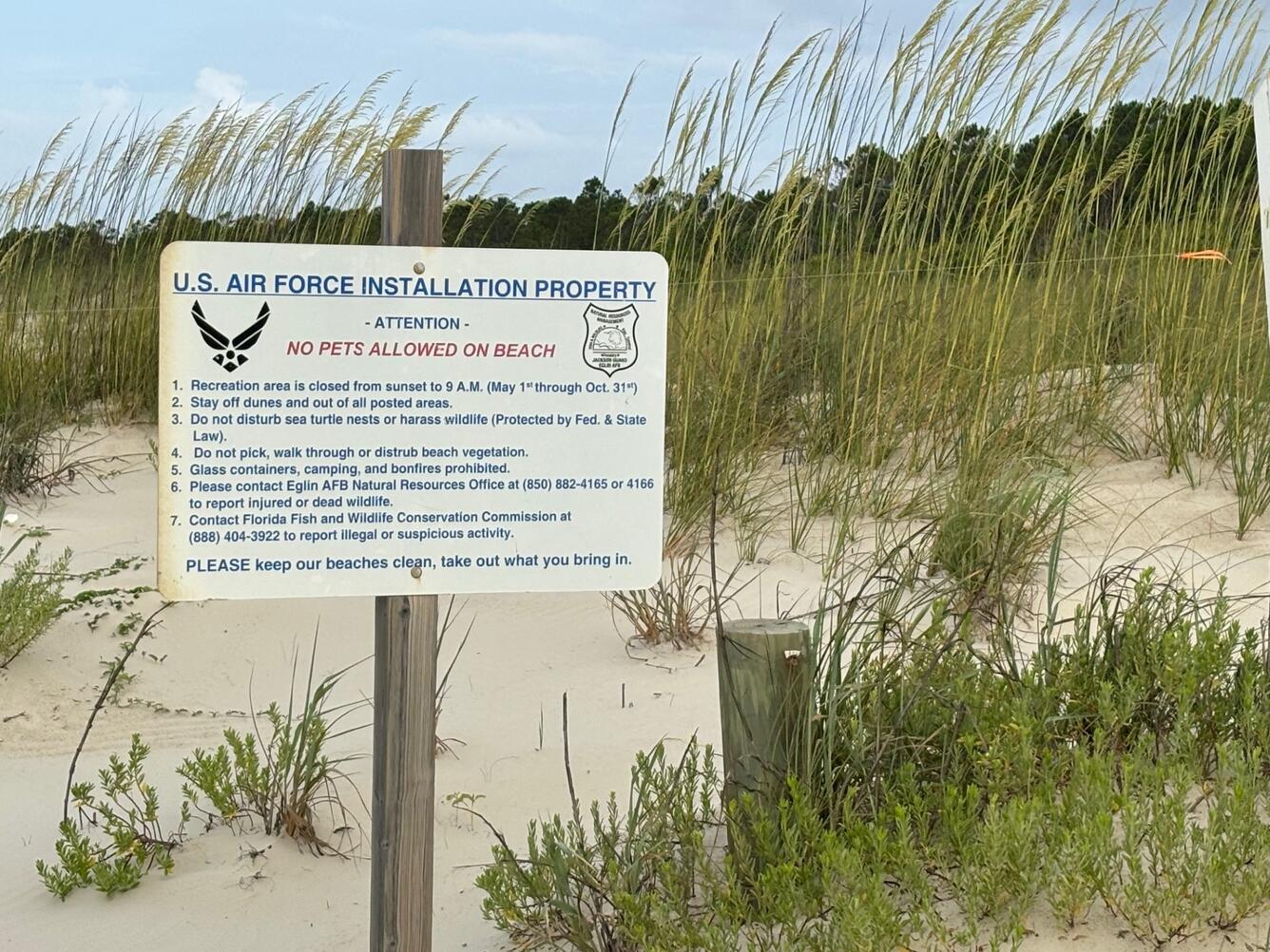 A sign in front of a sandy dune reads U.S. Air Force Installation Property