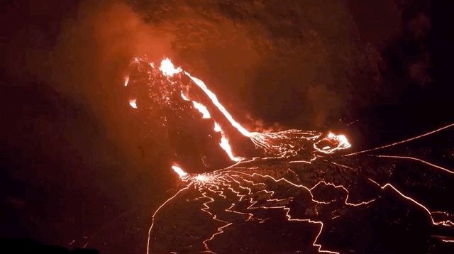 Lava bubbling out of a fissure at night time.