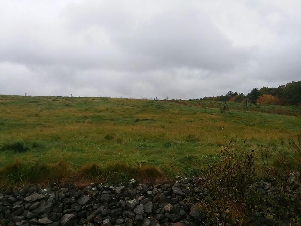 A view of a grassy hill covering an old landfill. 