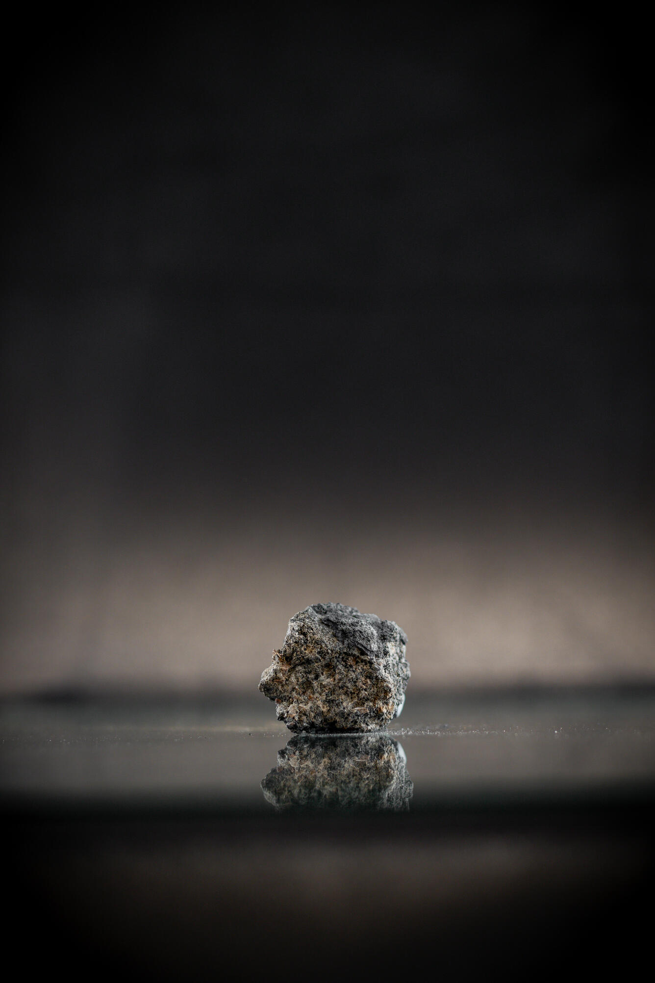  Isolated lump captured in high-definition photography, emphasizing flaky texture and dark gray color.