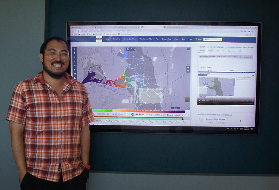 Lawrence Fujiwara stands next to display showing Bay-Delta real time electrical conductivity conditions.