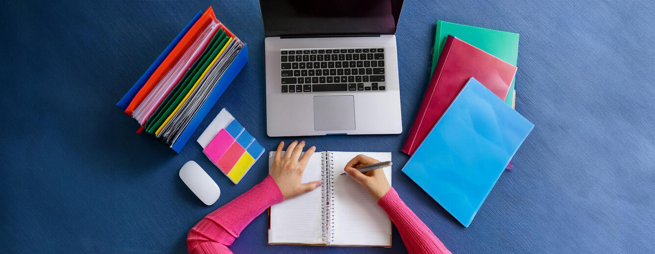 Woman taking notes at desk
