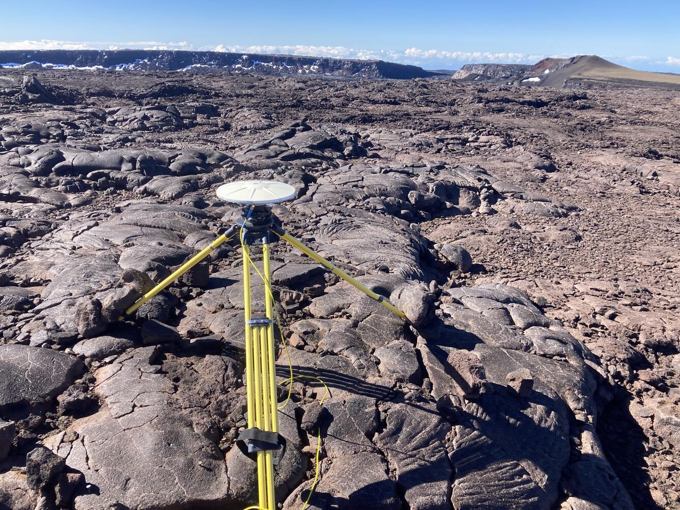 Color photograph of GPS tripod on lava flow