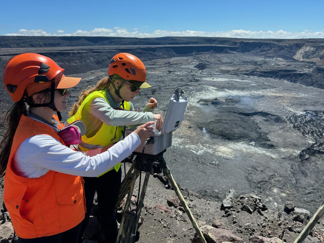 Color photograph of scientists checking volcano monitoring equipment