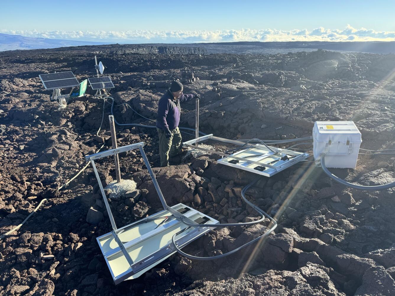 Color photograph of scientist examining equipment that has been knocked over by wind