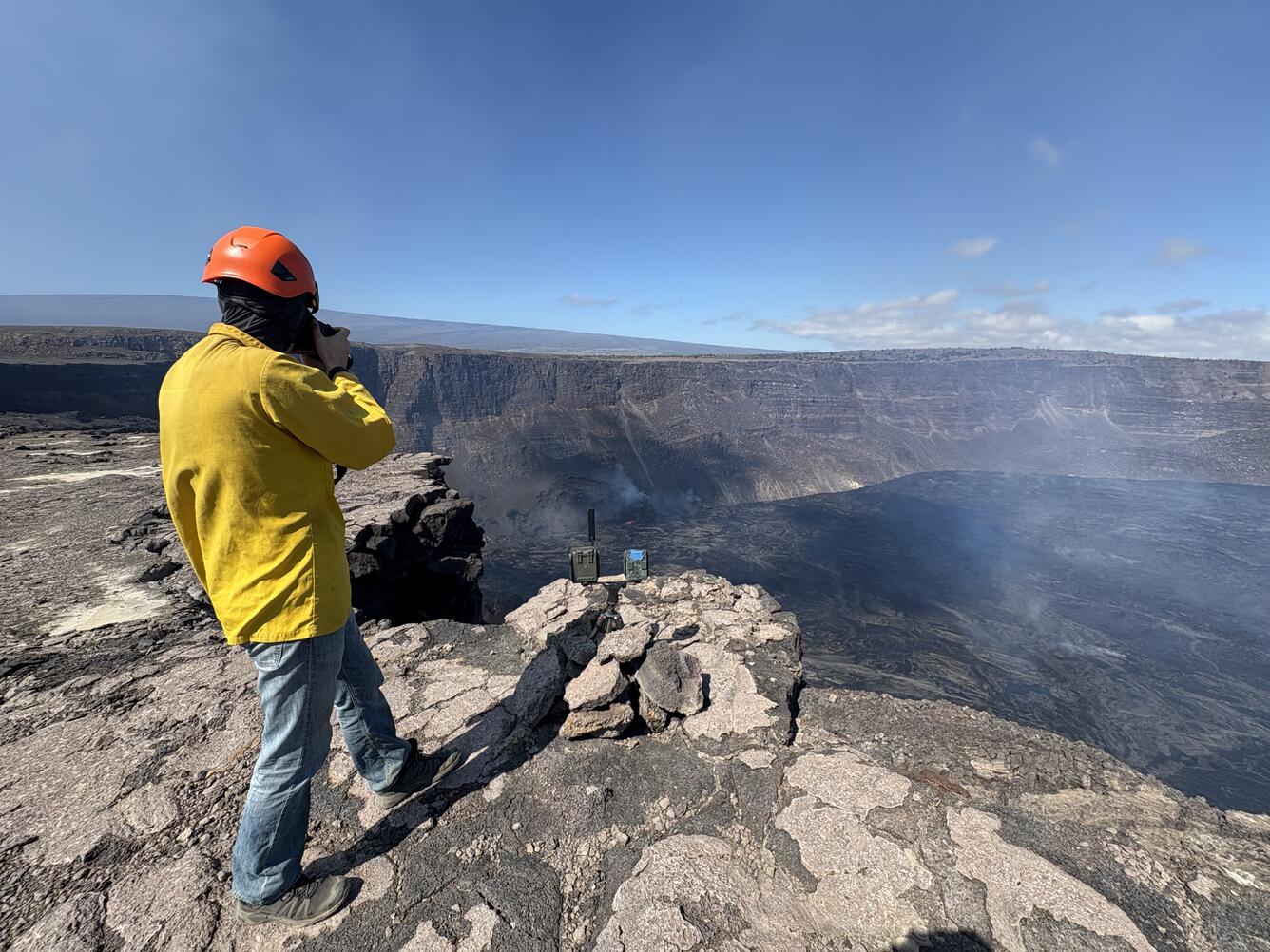 Color photograph of scientist on rim of caldera