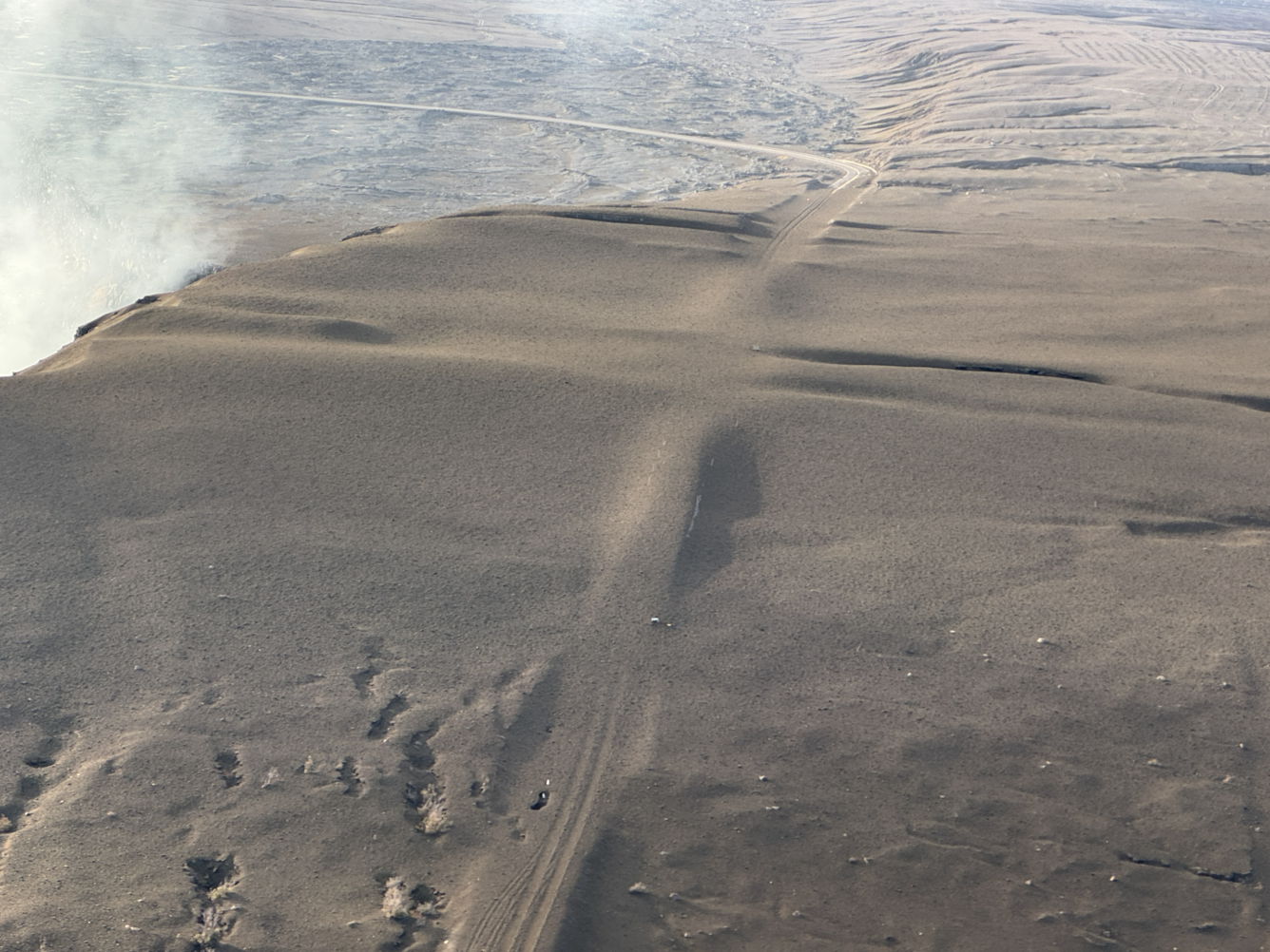 Color photograph of tephra blanket on road