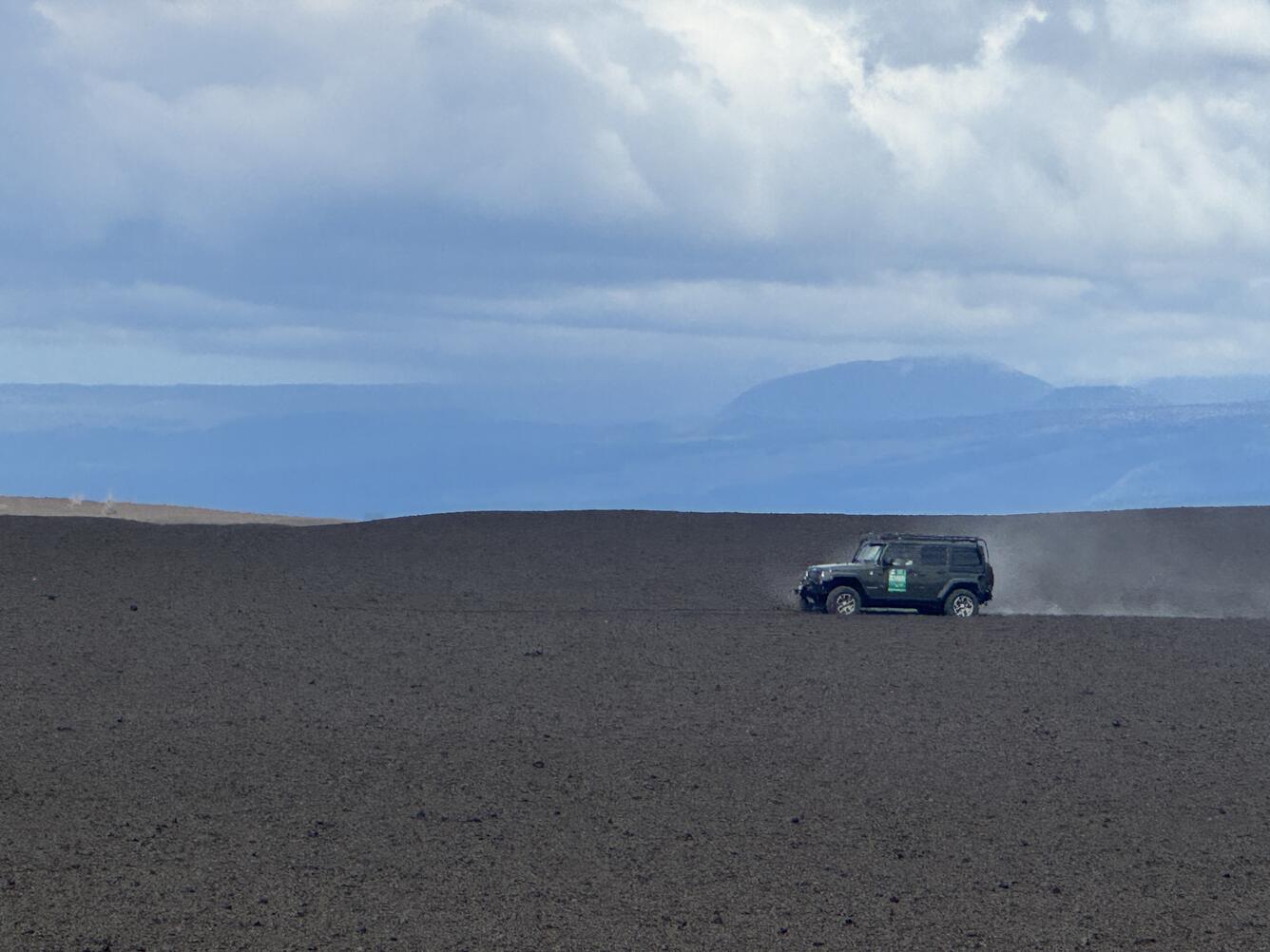 Color photograph of car driving on tephra deposit