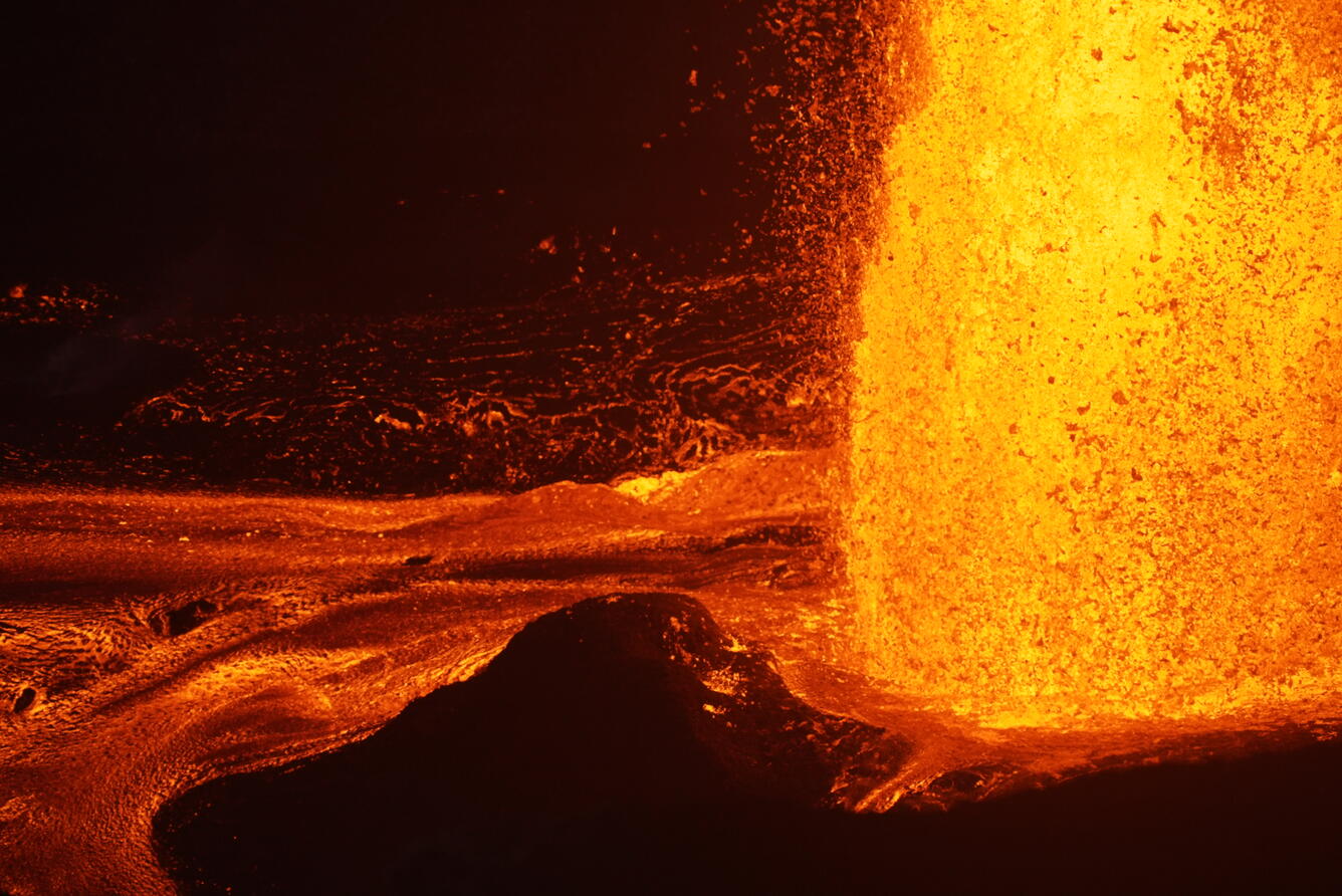 Color photograph of the base of a lava fountain at night