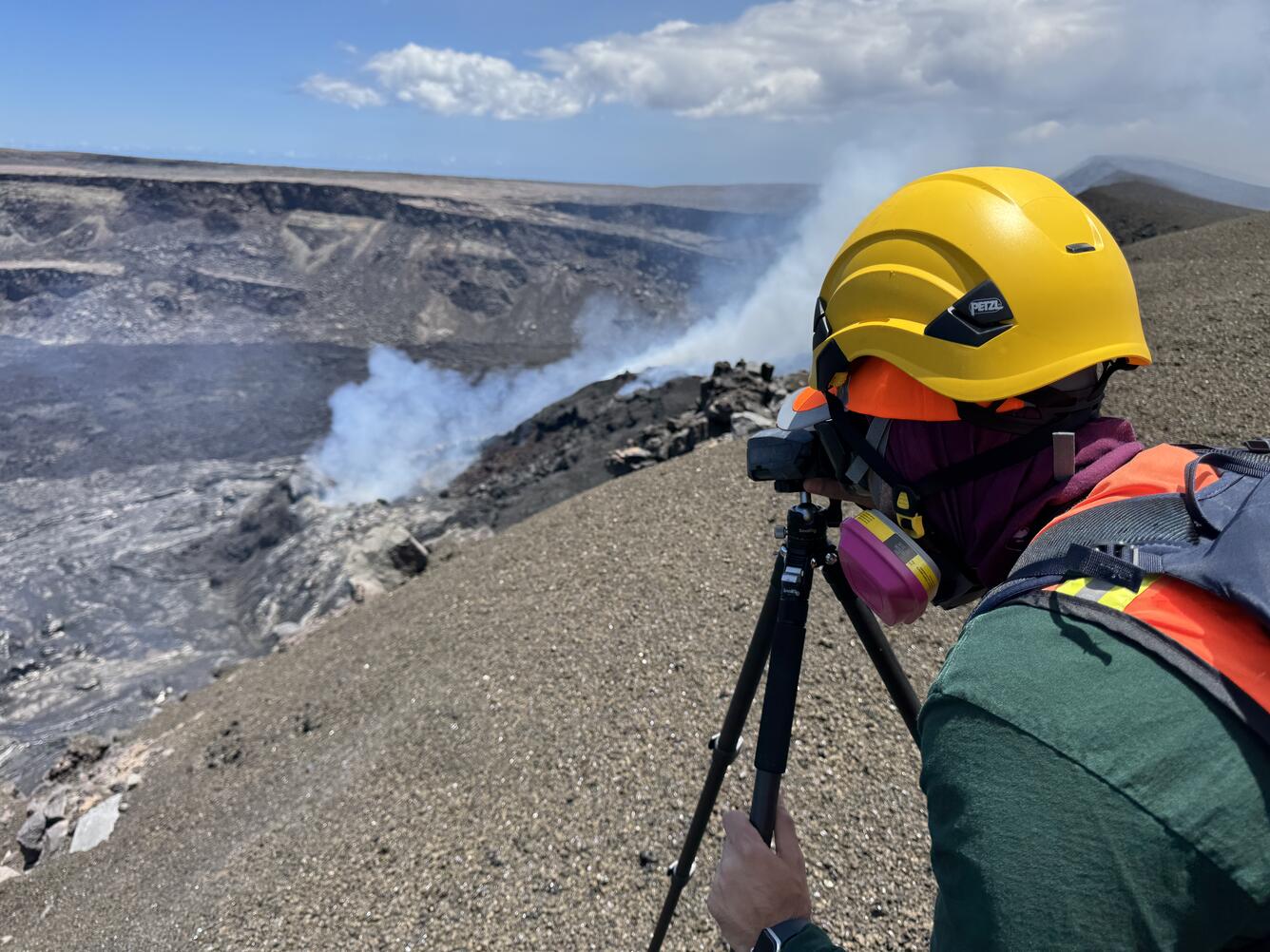 Color photograph of scientist on volcanic crater rim