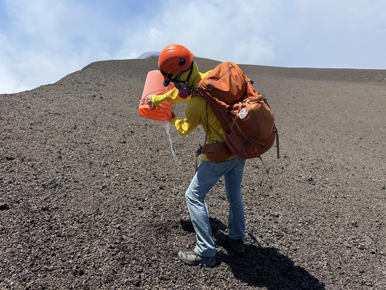 Color photograph of scientist emptying a bucket