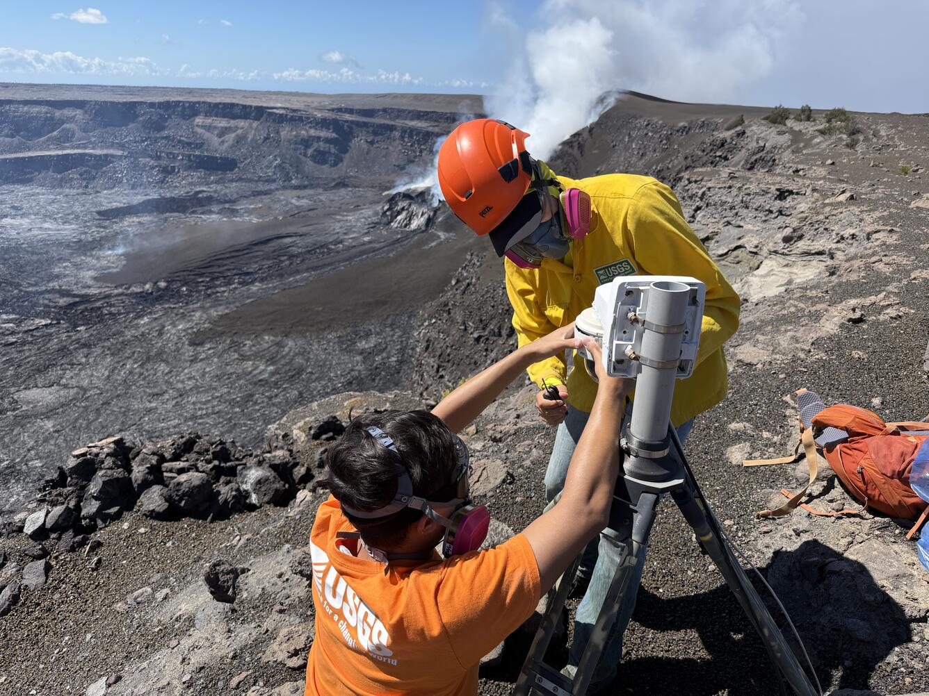 Color photograph of scientists servicing volcano monitoring camera