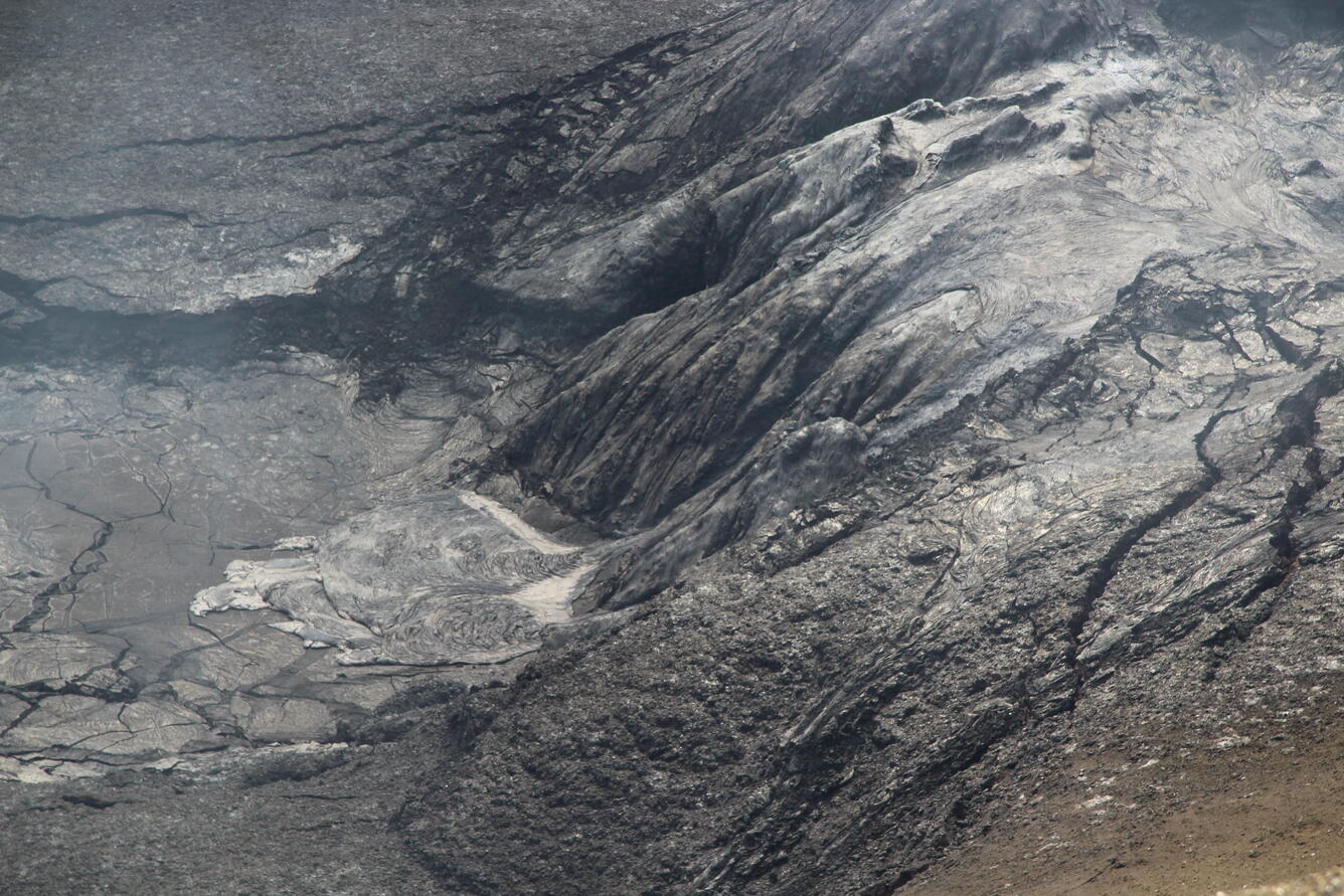 Color photo of cooled, black lava that overflowed from the north vent. 