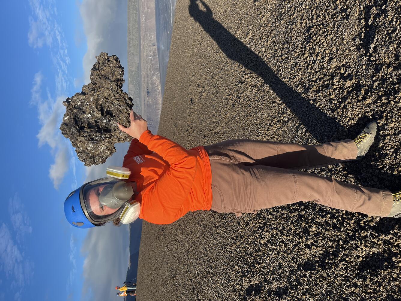 Color photograph of scientist holding recently erupted volcanic rock