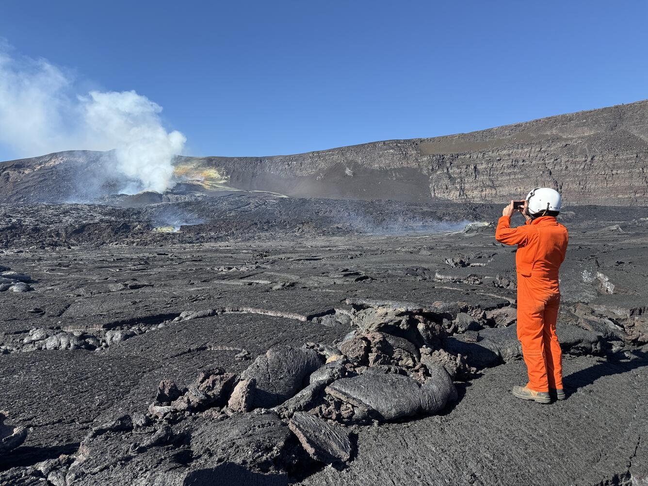 Color photograph of scientist documenting a volcanic vent