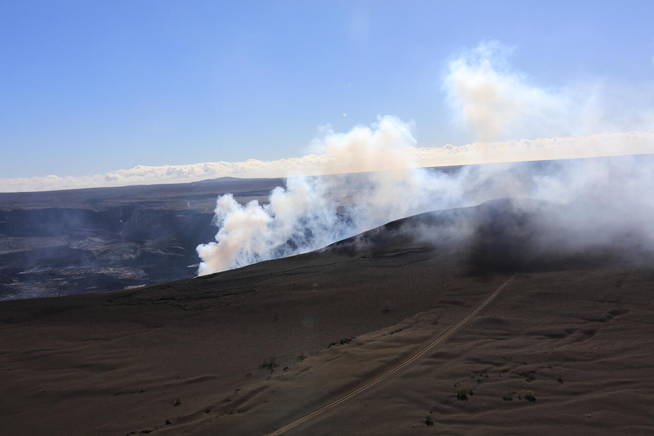 Color photograph of volcanic hill that is degassing