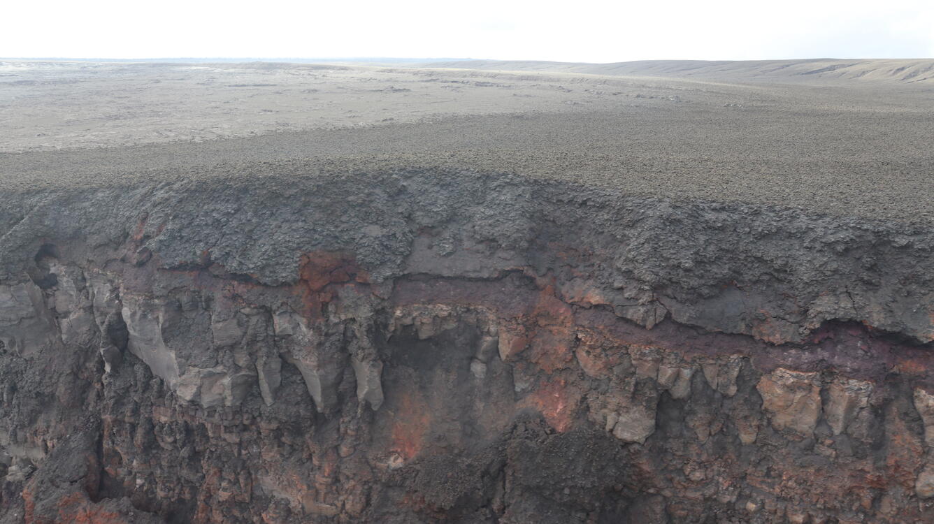 Color photograph of cliff exposing volcanic deposits