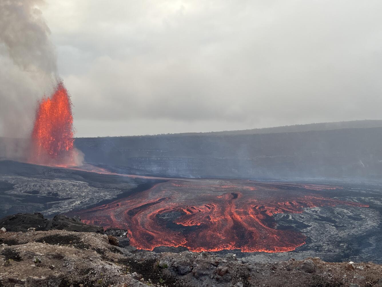 Color photograph of lava fountain and lava flow within crater