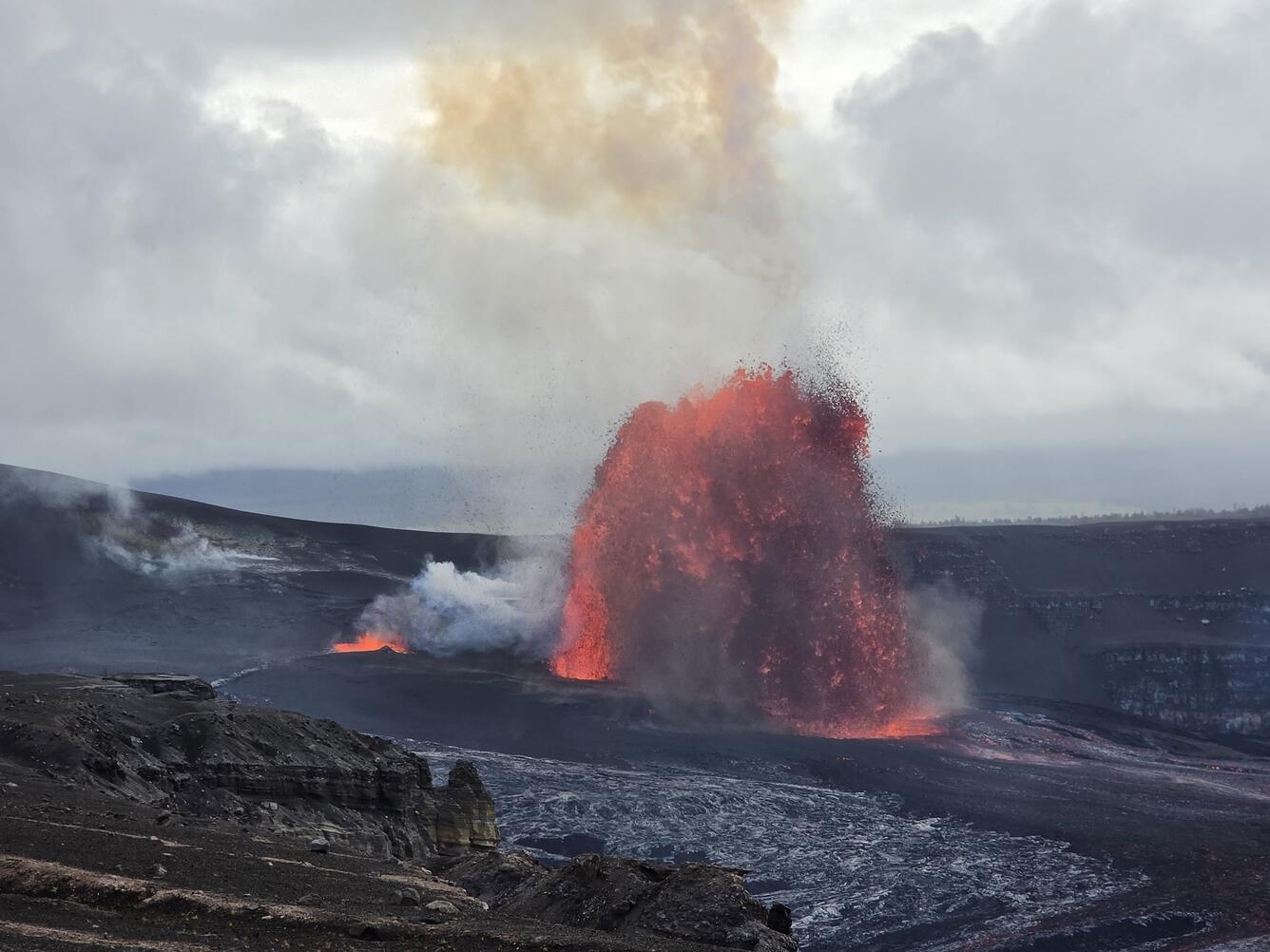 Color photograph of lava fountain with smaller spattering nearby