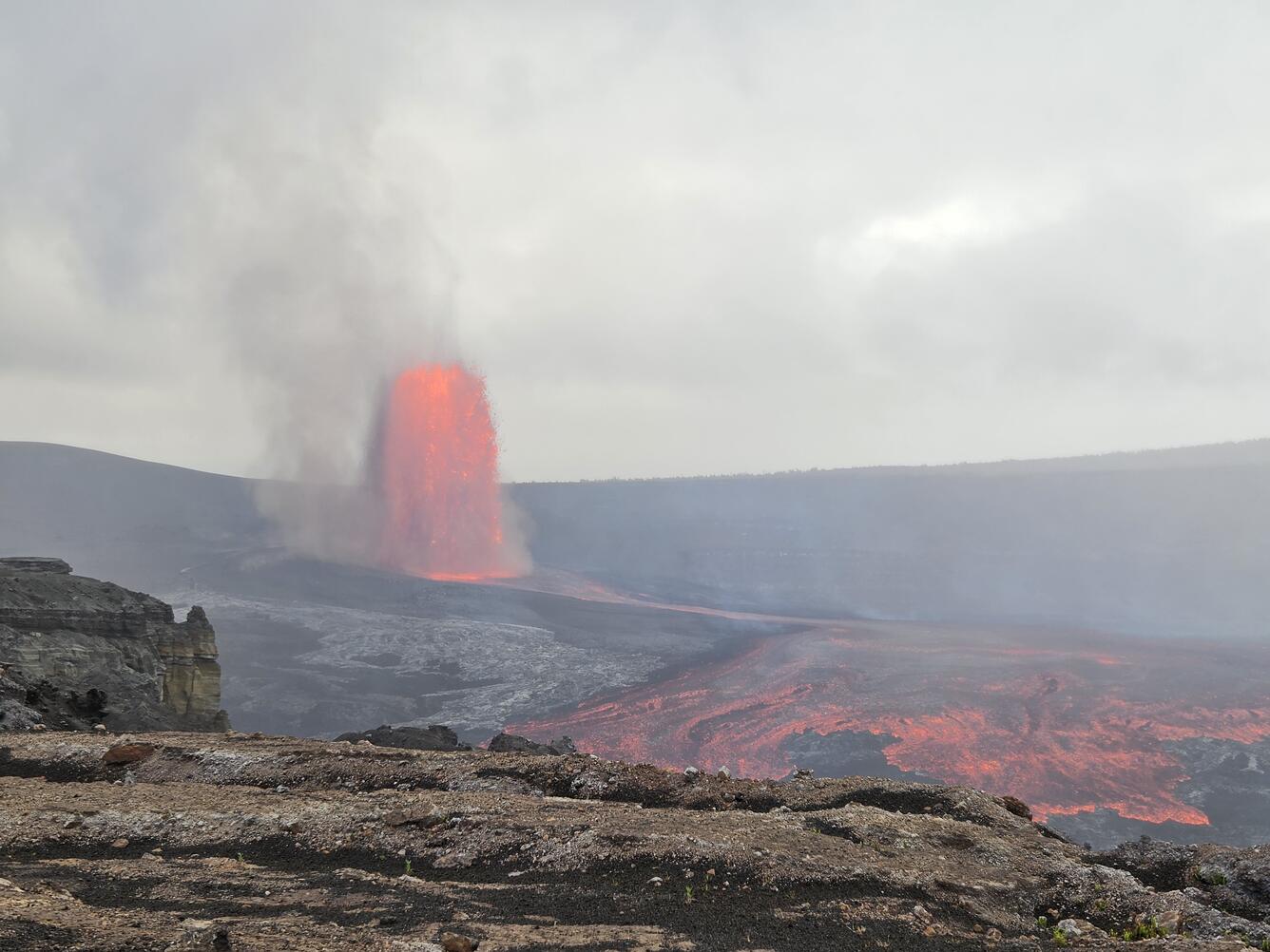 Color photograph of lava fountain and lava flow in crater