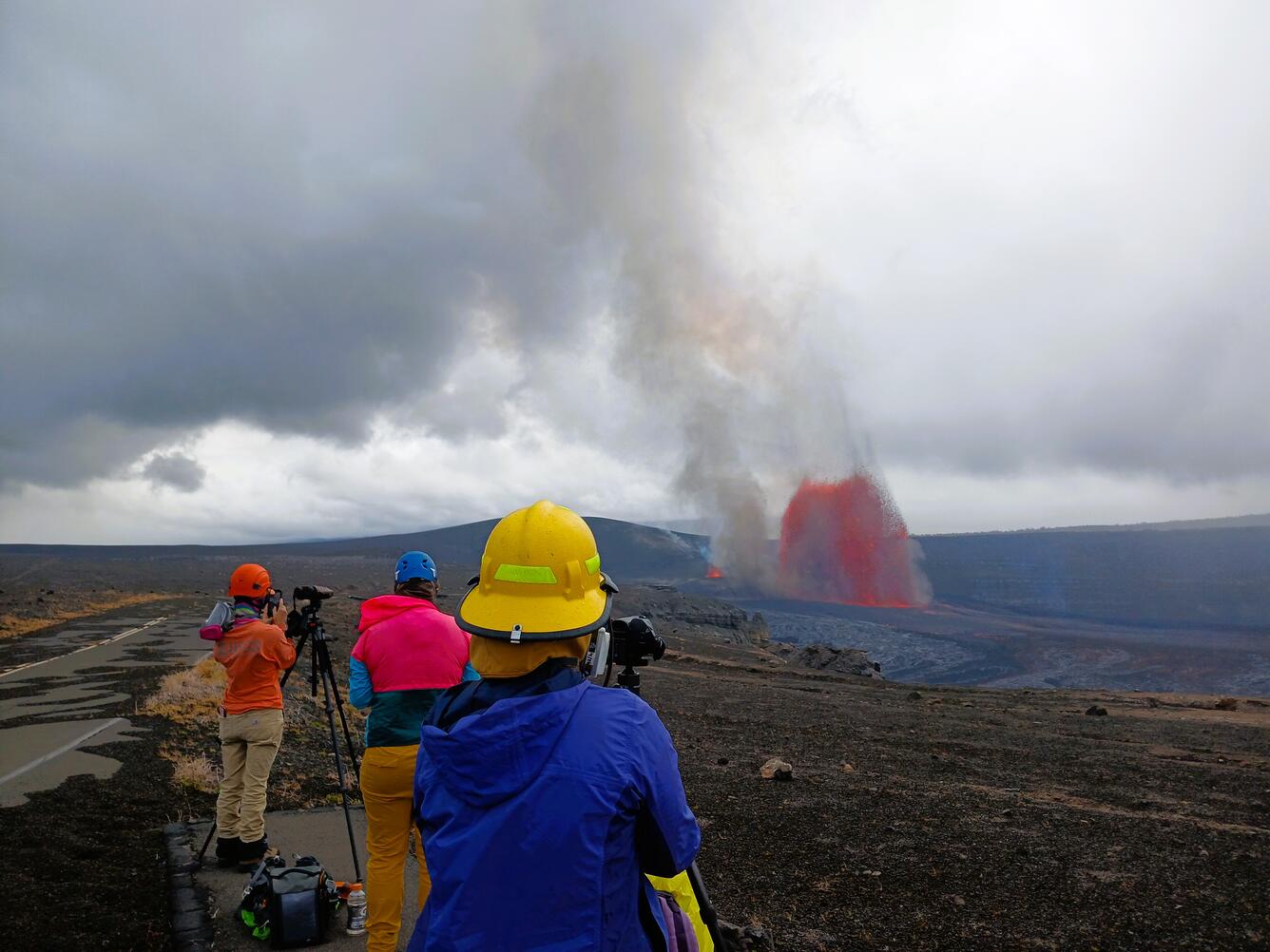 Color photograph of scientists observing volcanic eruption