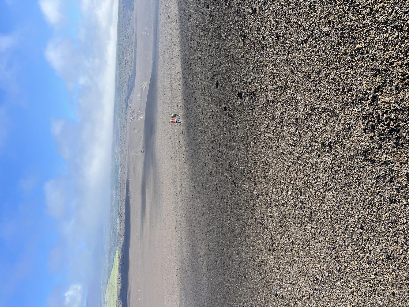 Color photograph of volcanic landscape with people in the background