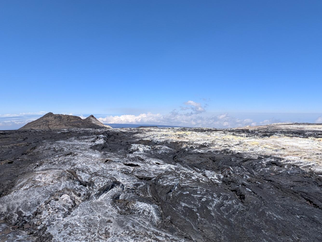 Color photograph of volcanic vent with sulfur deposits surrounding it