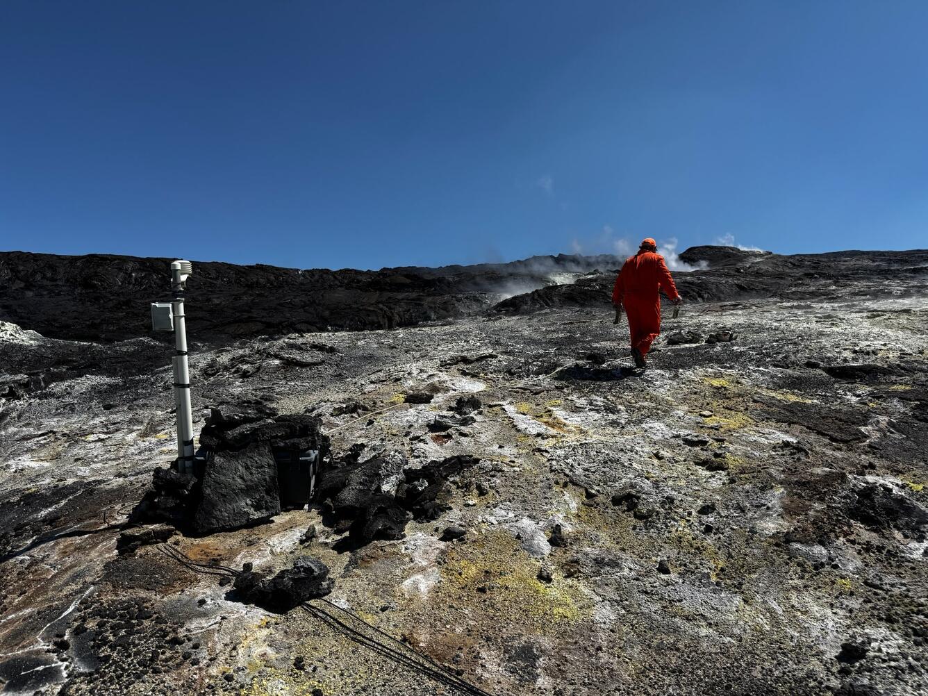 Color photograph of volcanic degassing area with monitoring instrumentation