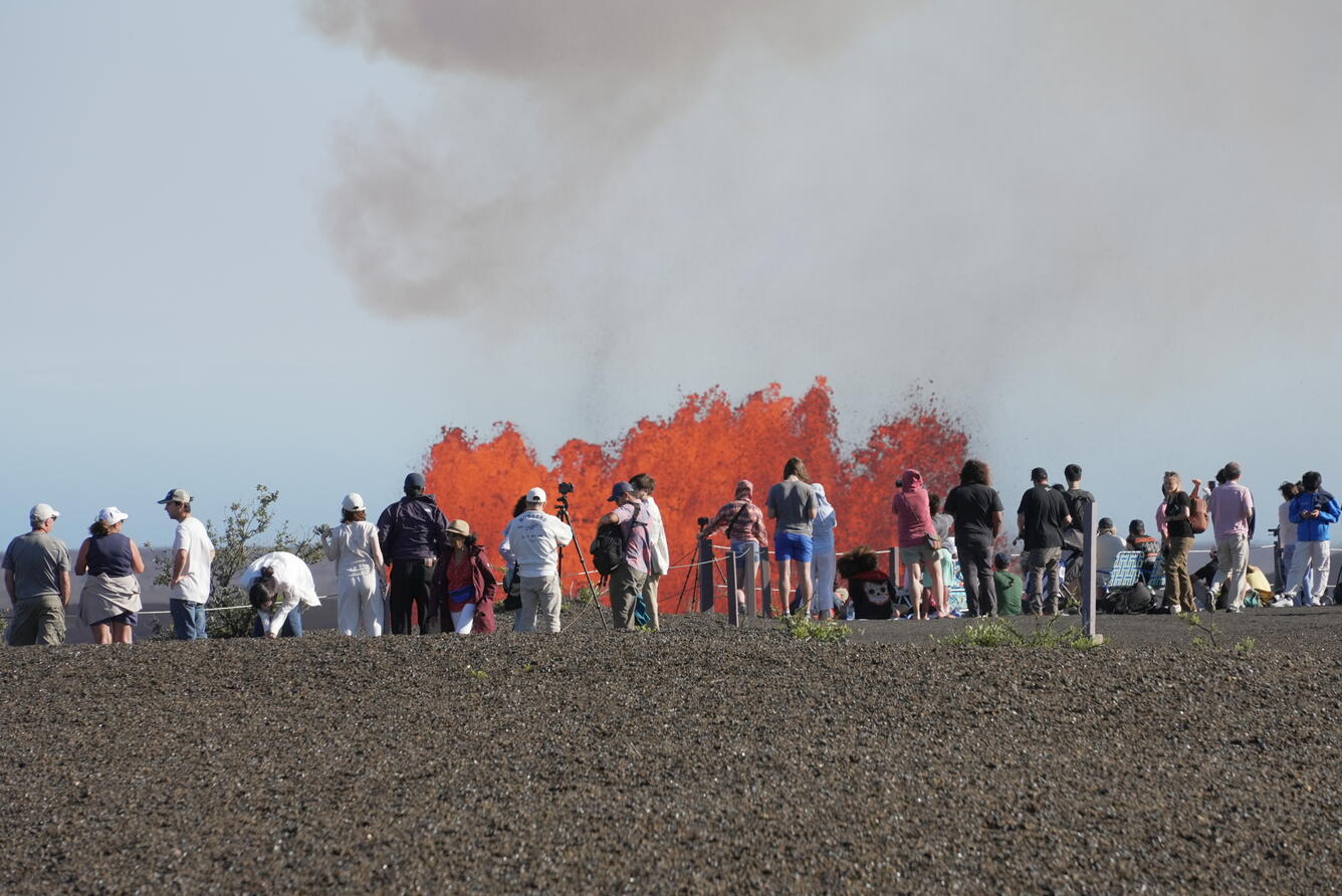 Color photograph of crowds watching lava fountain