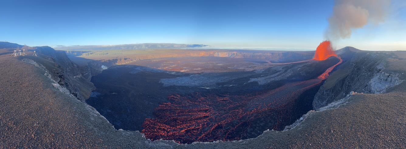 Color panoramic photo of volcanic crater with lava fountain and flows