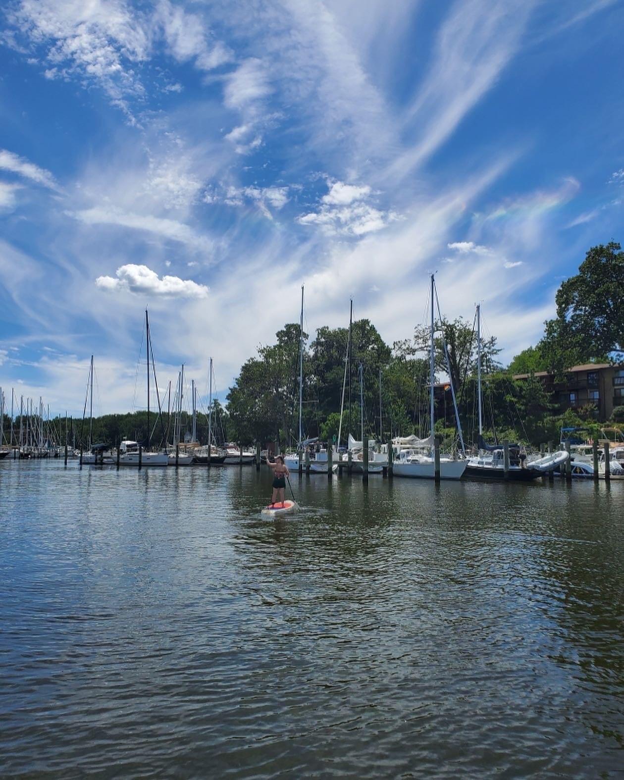   A photo of a person standing on a paddle board in the water. 