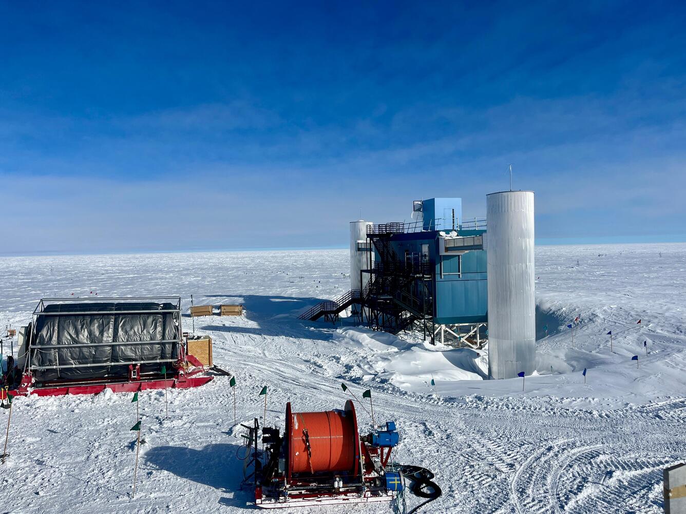  IceCube lab in the South Pole surrounded by snow and clear blue skies.