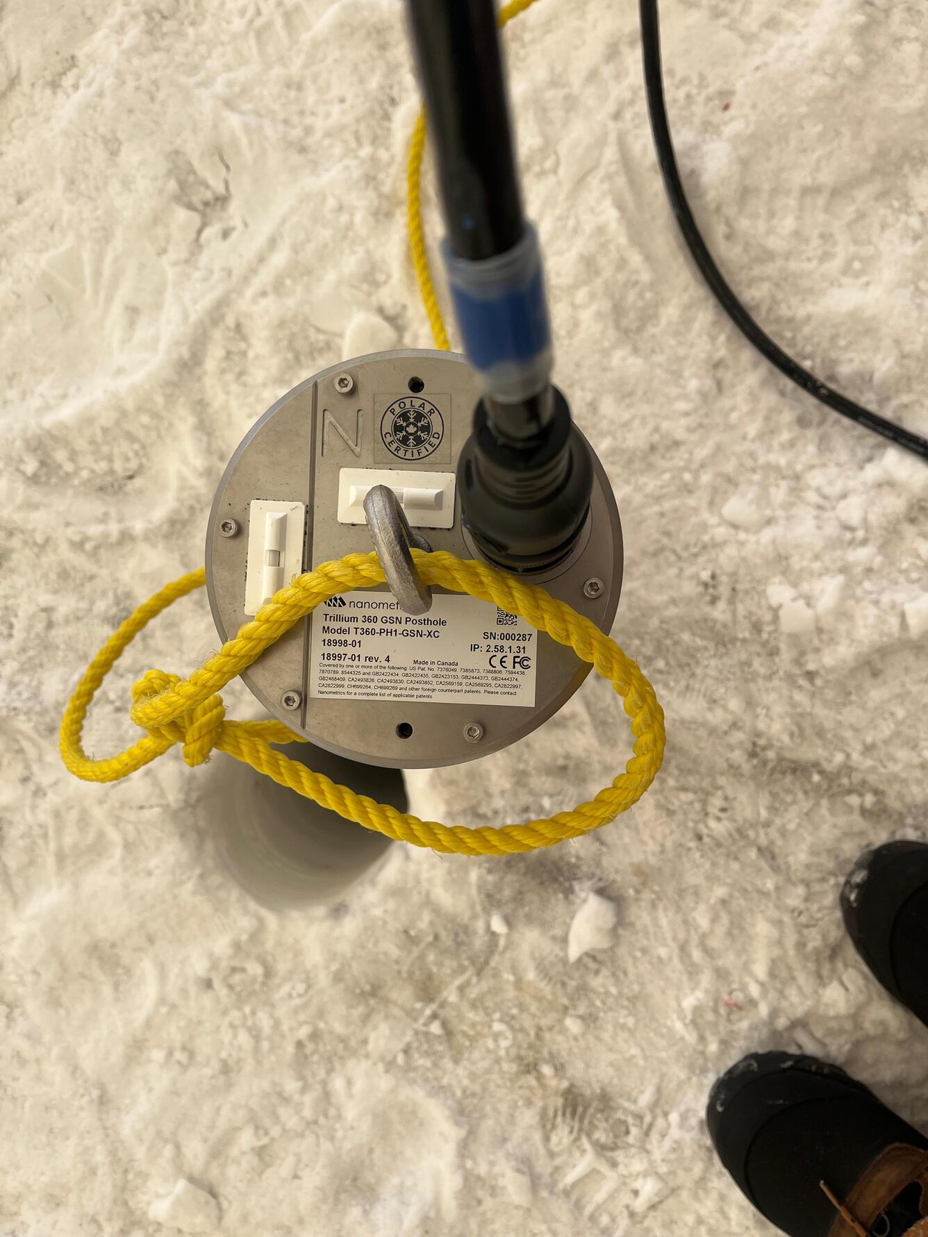 Seismometer being deployed into firn hole for testing in snow at the South Pole. 