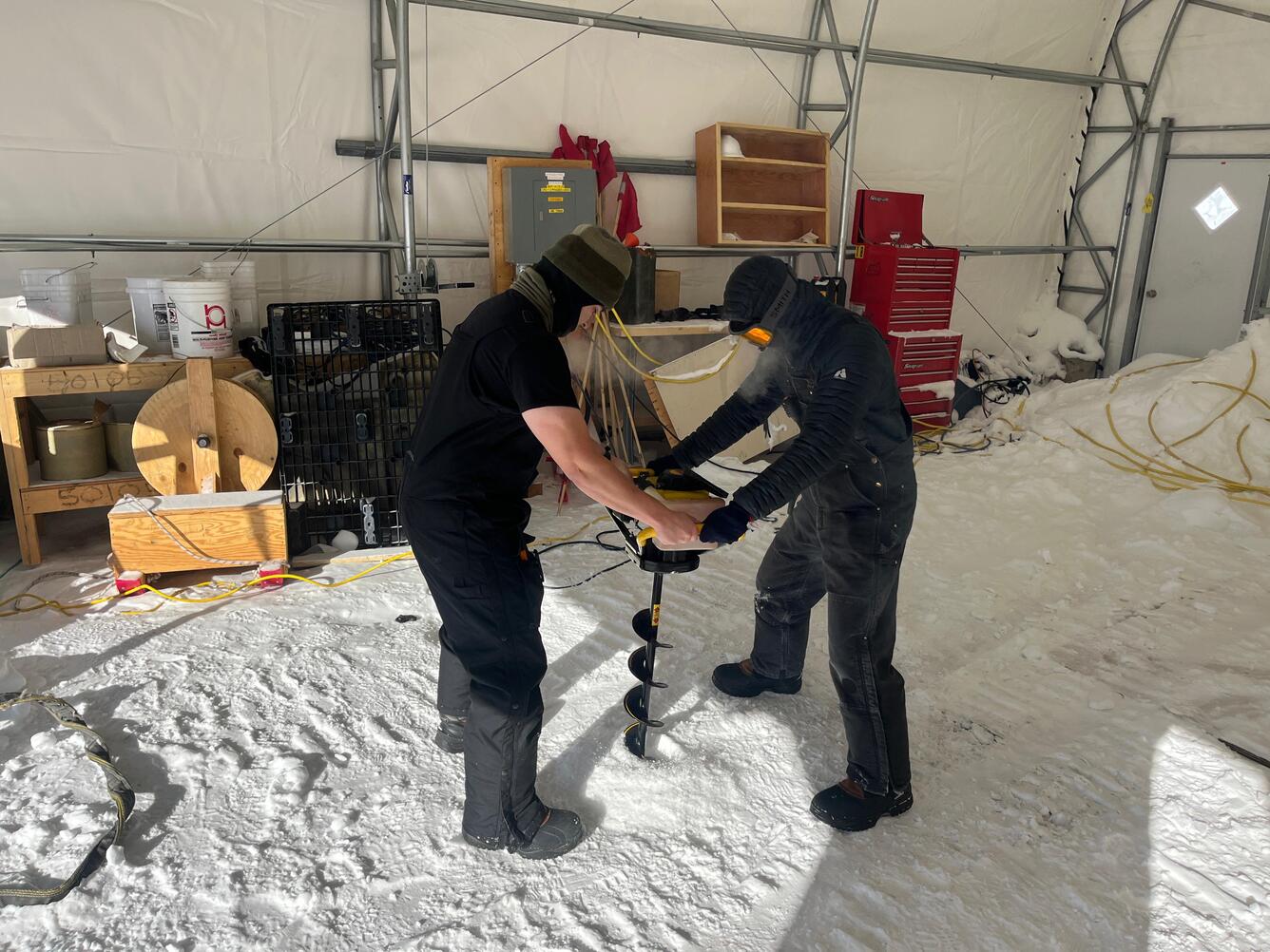 Ice Cube research assistants drilling a test hole at South Pole