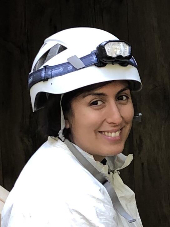 Ariel Leon wearing a white helmet with a head lamp and a white tyvek suit.