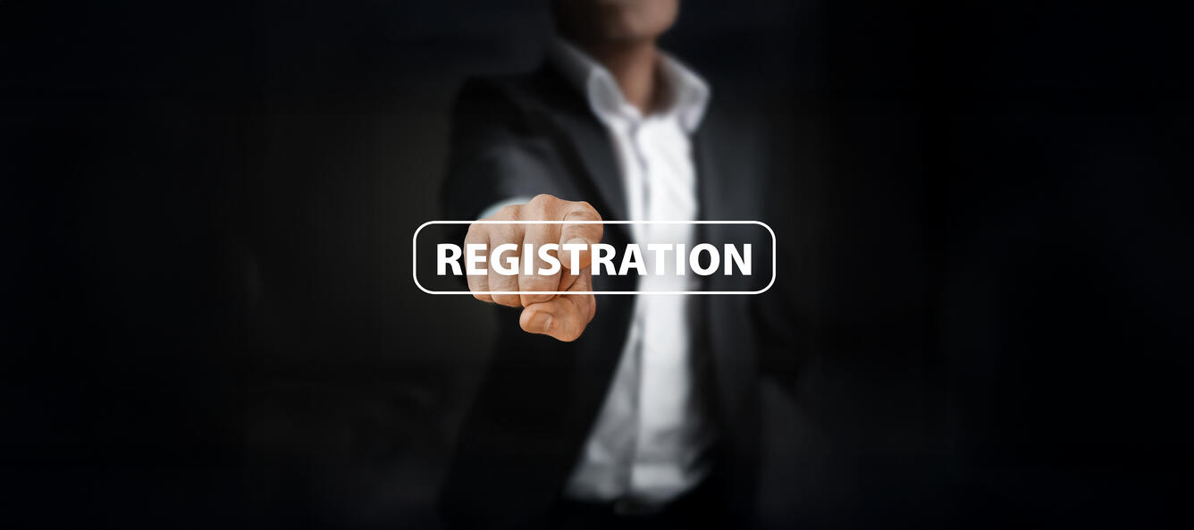 Image of a person reaching out to touch a digital button with the word registration 
