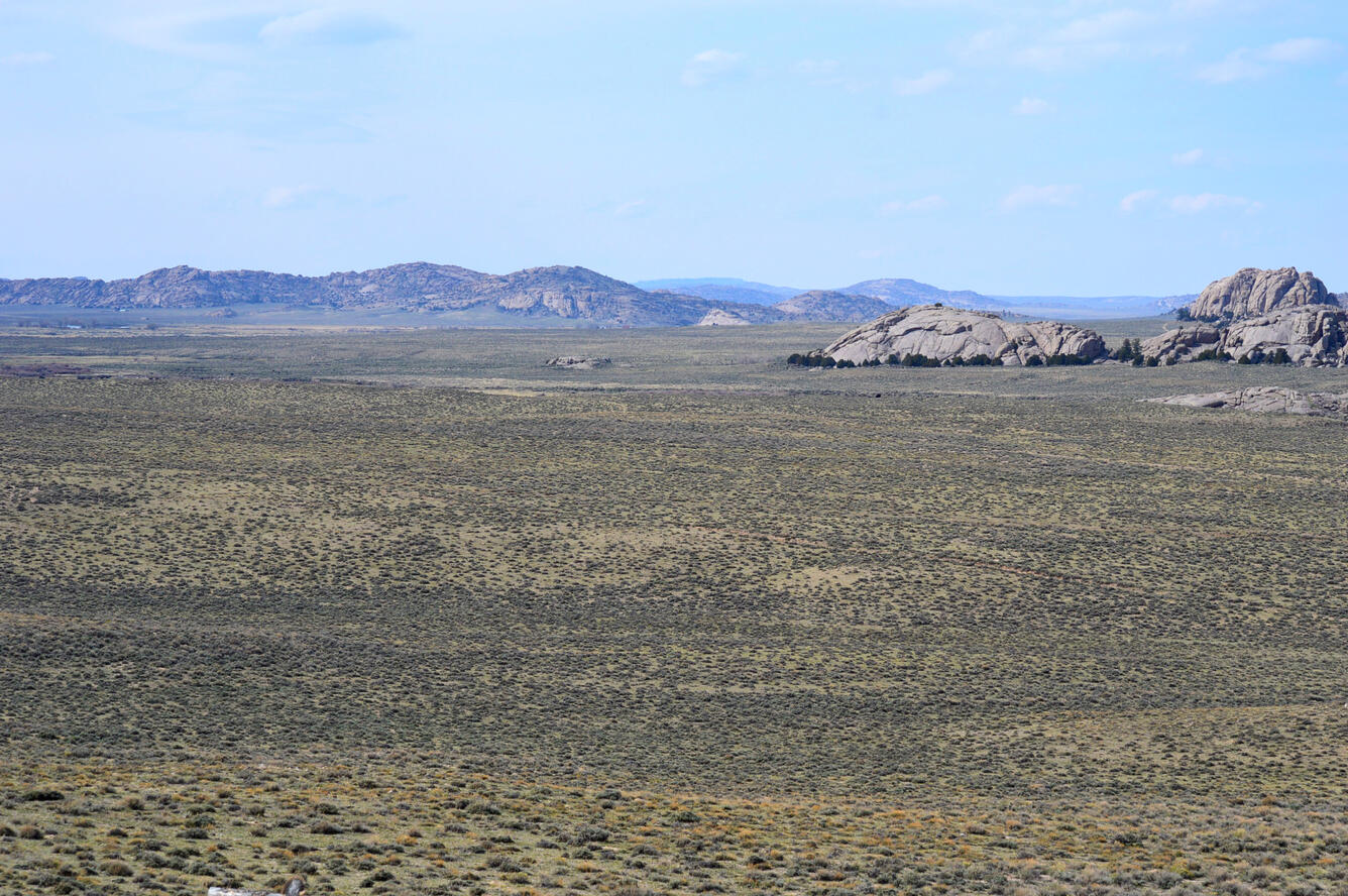 a large, flat landscape with small rocky hills in the background